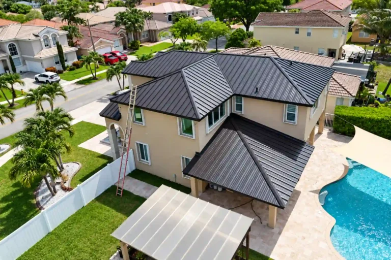 Dark standing seam metal roof on a two story South Florida home with a pool
