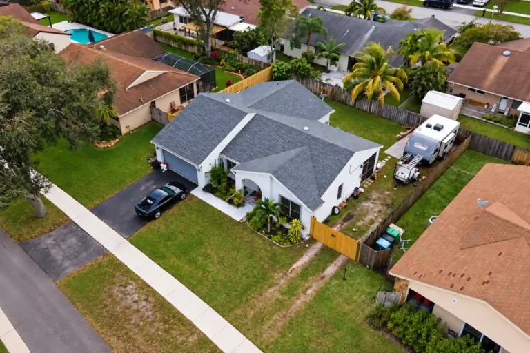 Gray shingle roof on a white single story home with a driveway